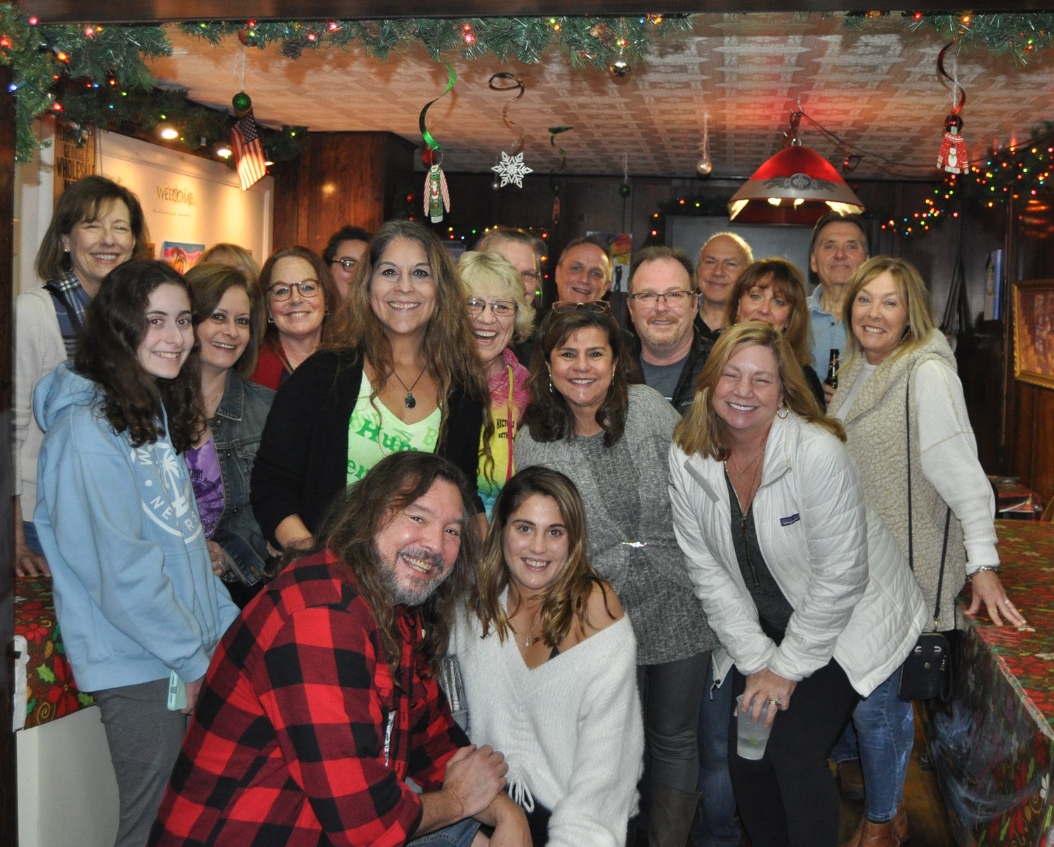 Kim Simons, standing center, in the green shirt, is surrounded by friends and family at Hector’s Inn in Bethel, NY to celebrate Simons’ team Bah Hum Bakers and their $25,000 first prize win on the Food Network’s “Holiday Wars.”